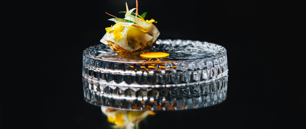 A dish on a cristal plate at 2 Michelin Star Restaurant Vinkeles, in luxury boutique hotel The Dylan Amsterdam, member of the Leading Hotels of the World.