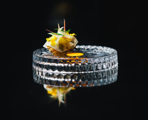 A dish on a cristal plate at 2 Michelin Star Restaurant Vinkeles, in luxury boutique hotel The Dylan Amsterdam, member of the Leading Hotels of the World.